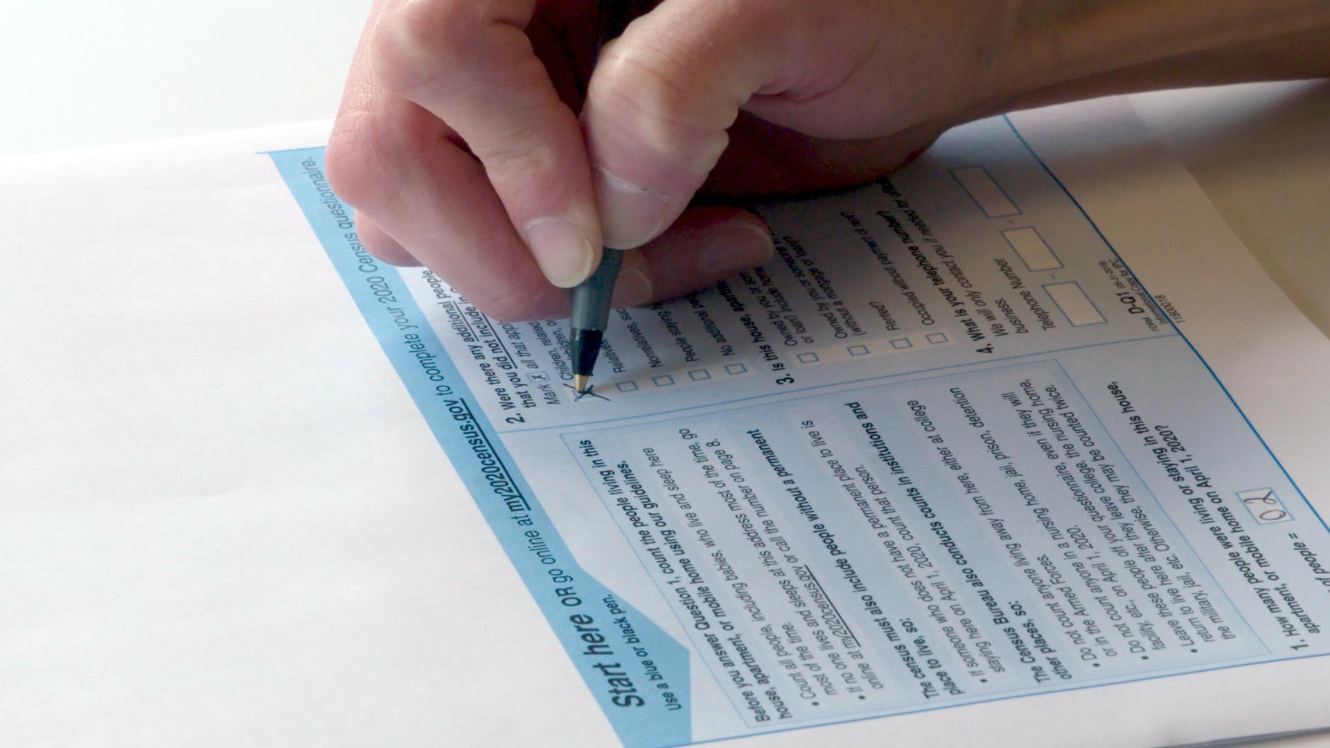 A photo of a person filling out a 2020 census form.