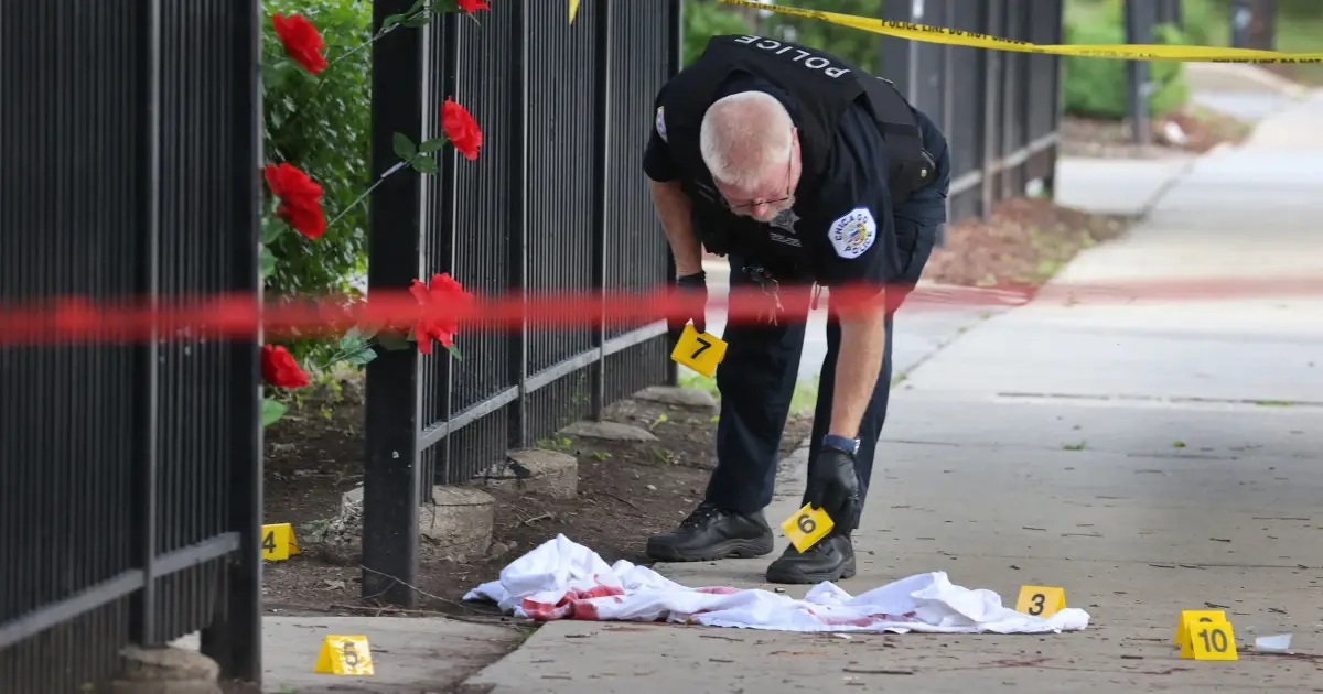 A photo of a Chicago police officer marking evidence at a crime scene.